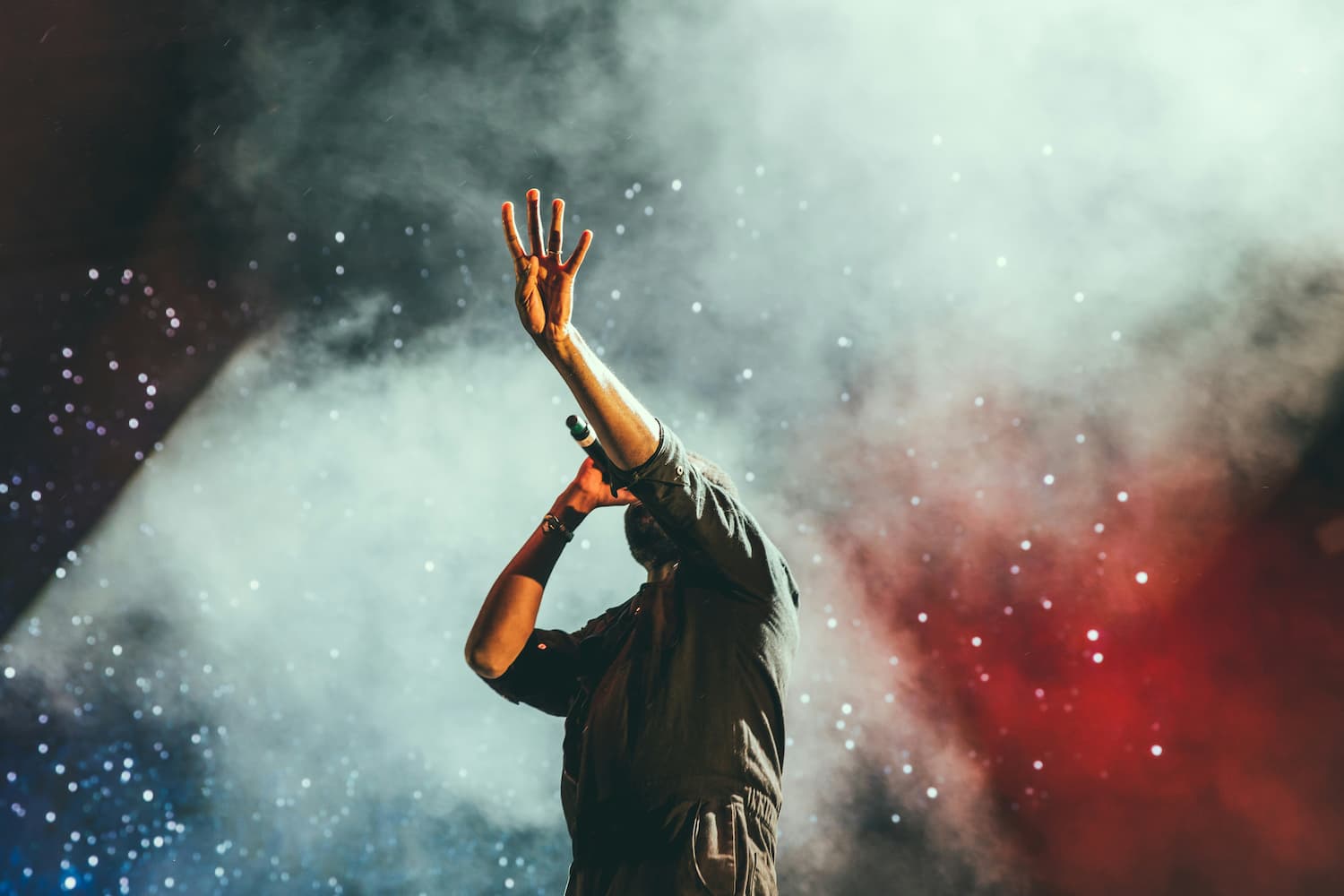 A perform sings into a microphone on a stage